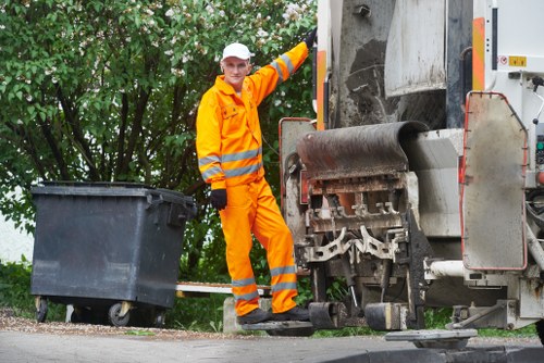Workers placing a skip on a busy construction site